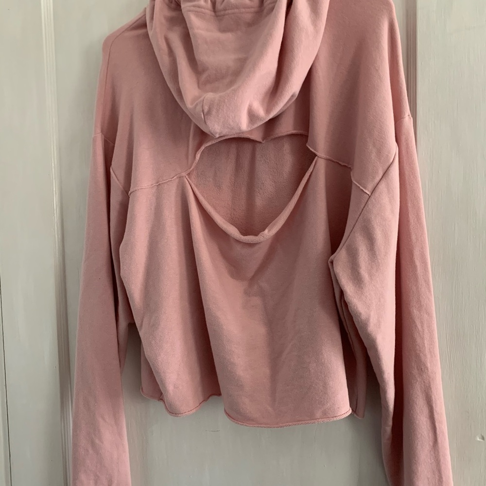 Pink cropped hoodie with open back.